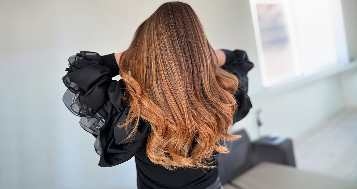 mulher com cabelo longos lisos e luzes acobreado